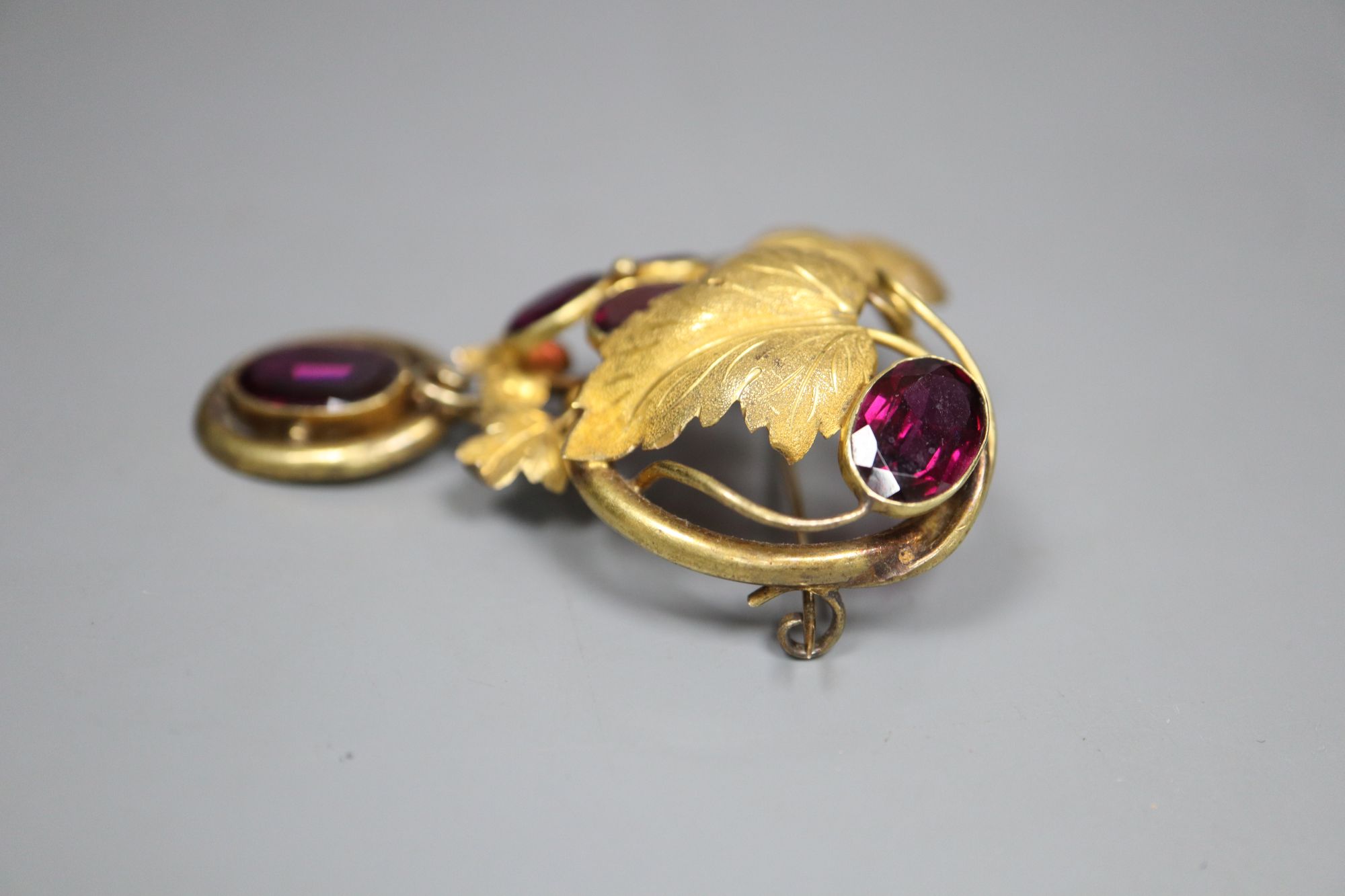 A Victorian garnet and pinchbeck fruiting scroll brooch, 5.75cm